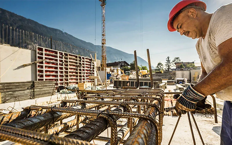 Ein Eisenbieger arbeitet auf einer Baustelle.