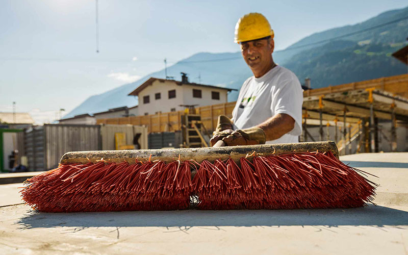 Bauarbeiter fegt Baustelle